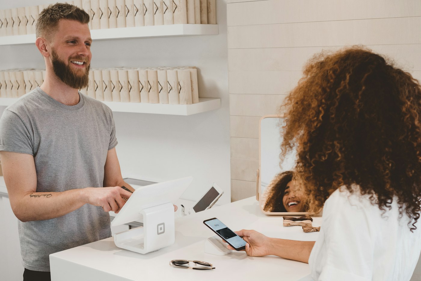 A customer paying with a phone at a card reader