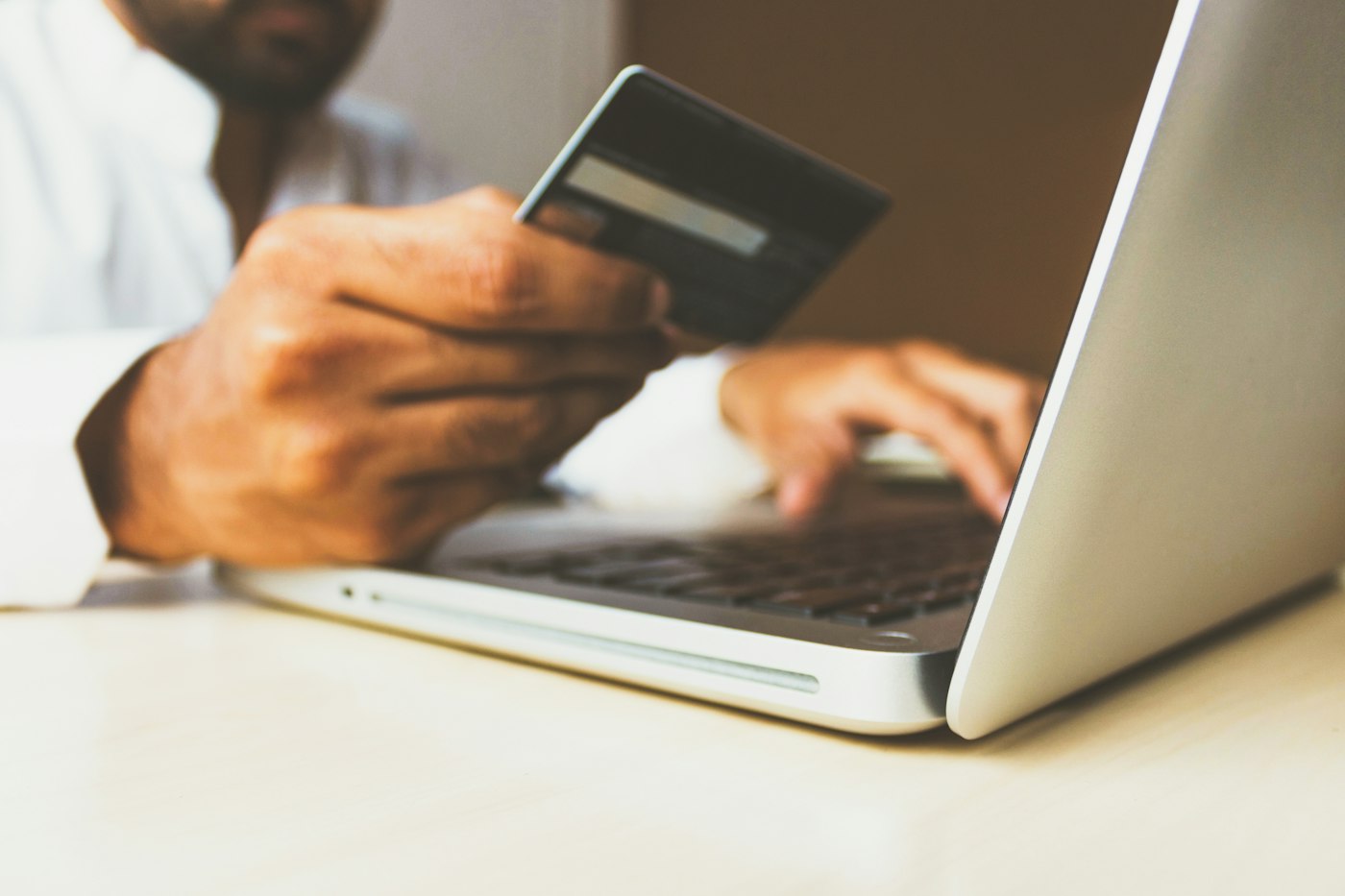 Hands holding a bank card while paying online